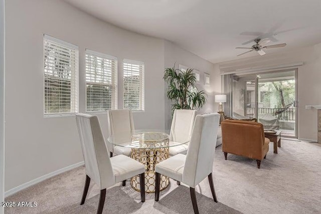 carpeted dining area with a healthy amount of sunlight and ceiling fan