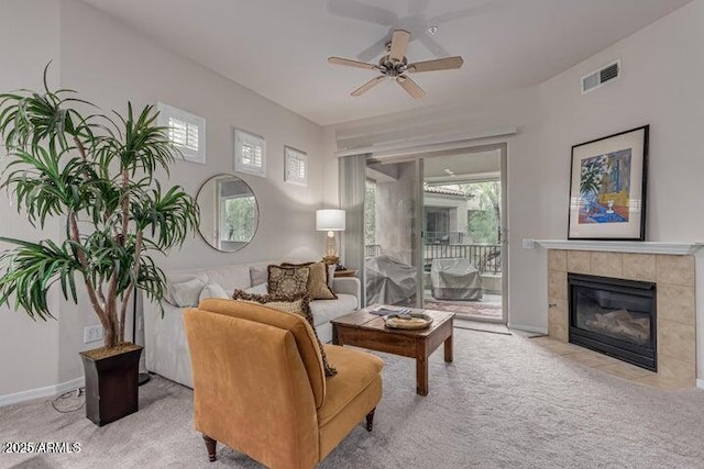 living room with ceiling fan, light colored carpet, a healthy amount of sunlight, and a tiled fireplace