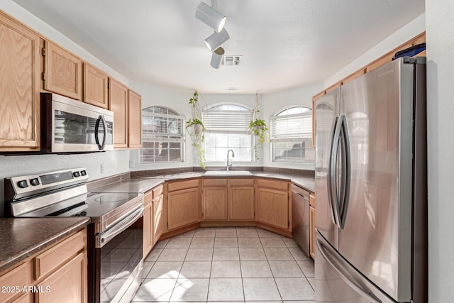 kitchen featuring light brown cabinetry, sink, light tile patterned floors, and stainless steel appliances