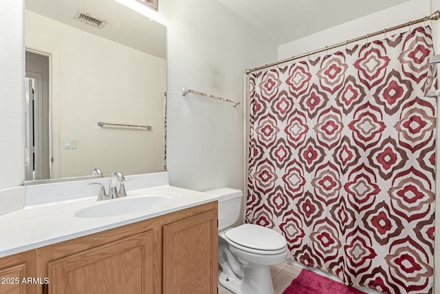 bathroom with tile patterned flooring, vanity, and toilet