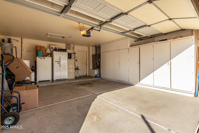 garage with a garage door opener, white fridge with ice dispenser, and white fridge