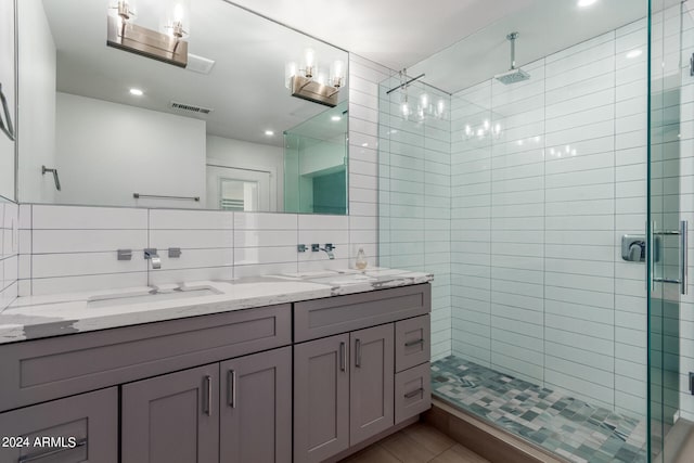 bathroom with a shower with door, vanity, tile walls, and backsplash