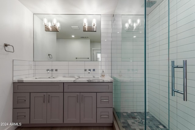 bathroom with tasteful backsplash, a shower with shower door, and vanity