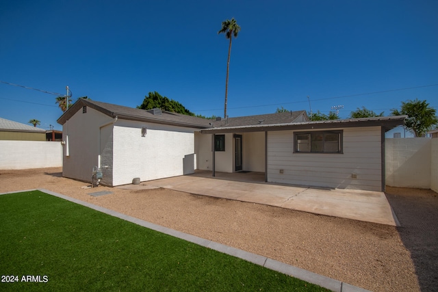 rear view of property with a yard and a patio area