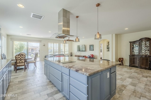 kitchen featuring a kitchen island, pendant lighting, gray cabinetry, island exhaust hood, and light stone countertops