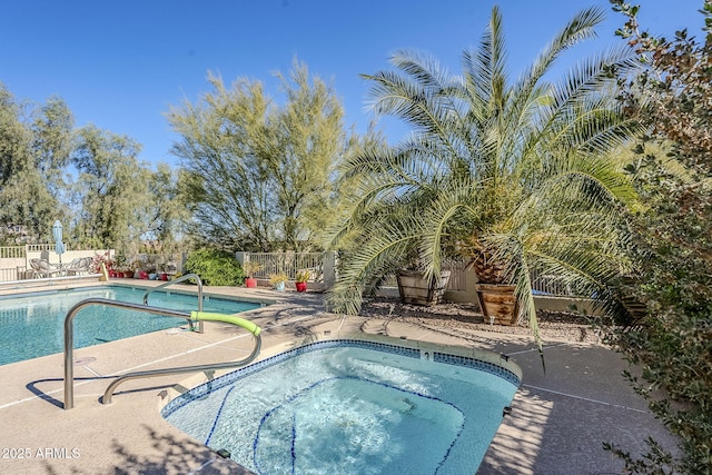 view of swimming pool featuring a patio area and an in ground hot tub