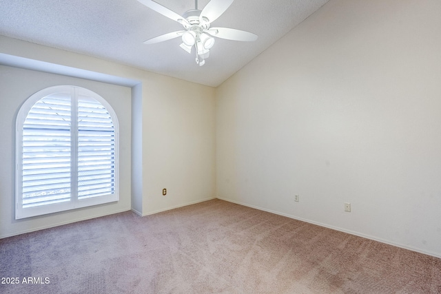 carpeted spare room featuring lofted ceiling and ceiling fan