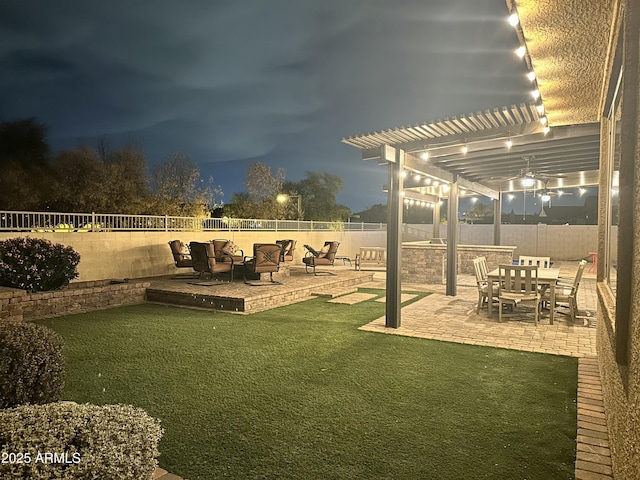 yard at night featuring a patio, a fenced backyard, and a pergola
