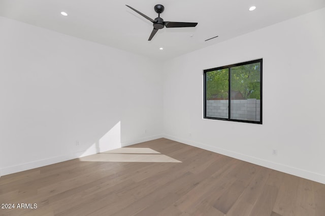 empty room with ceiling fan and light hardwood / wood-style flooring