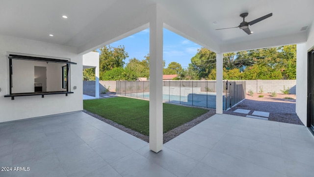 view of patio with a fenced in pool and ceiling fan