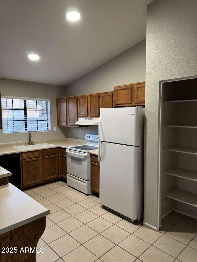 kitchen featuring lofted ceiling, sink, white appliances, and light tile patterned flooring