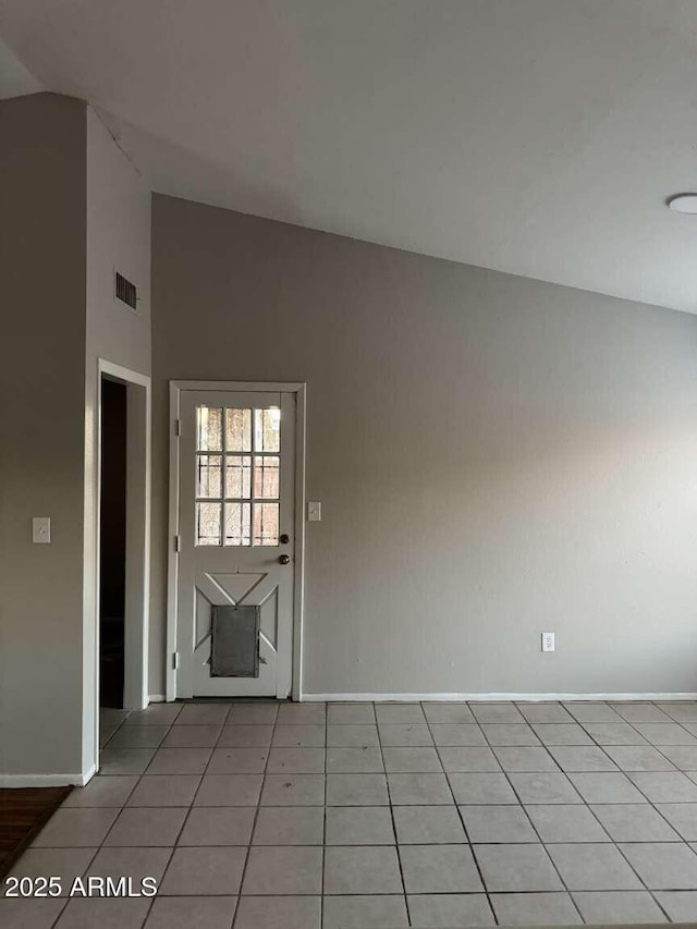 tiled empty room with lofted ceiling