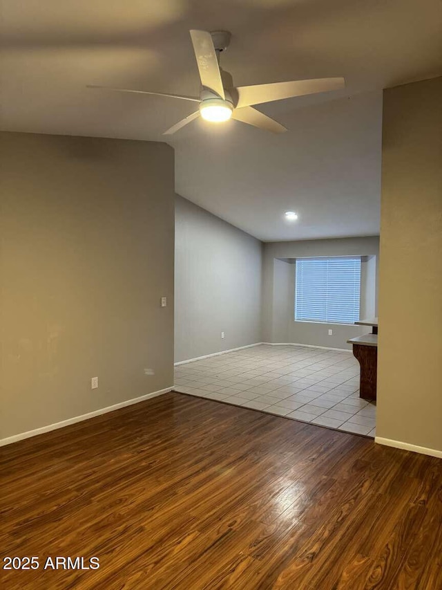 unfurnished room with ceiling fan, lofted ceiling, and hardwood / wood-style floors