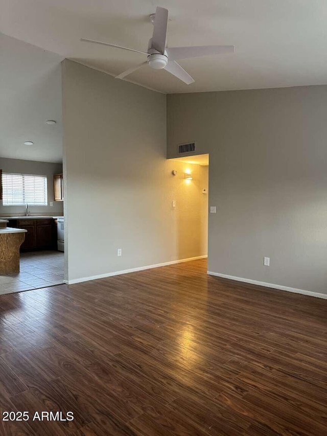 unfurnished room featuring dark wood-type flooring, ceiling fan, lofted ceiling, and sink