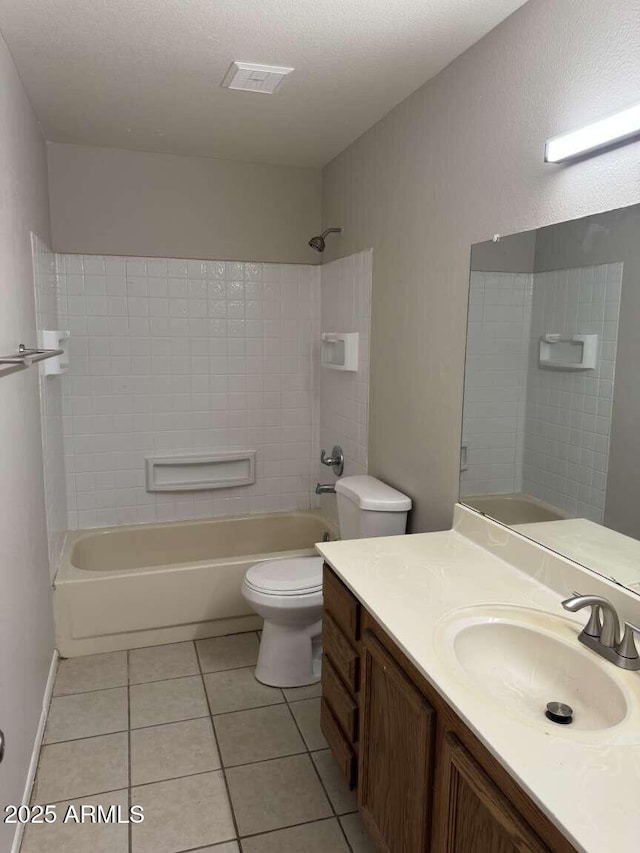 full bathroom with tiled shower / bath, tile patterned floors, toilet, and vanity