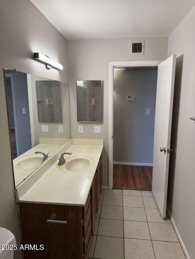 bathroom featuring tile patterned floors, vanity, and a textured ceiling