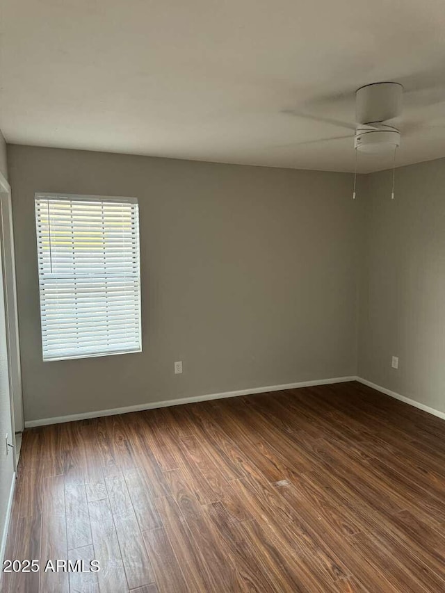 spare room featuring dark wood-type flooring and ceiling fan