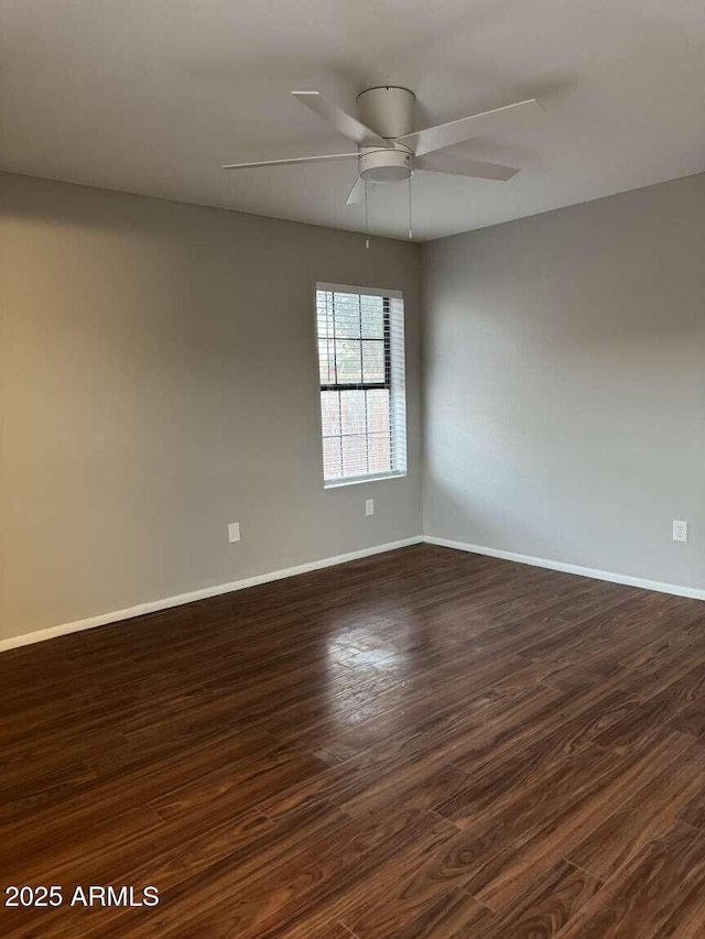 spare room featuring dark wood-type flooring and ceiling fan