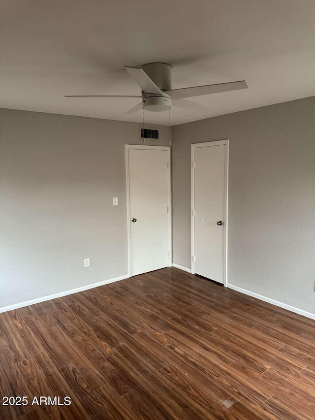 unfurnished room featuring dark wood-type flooring and ceiling fan