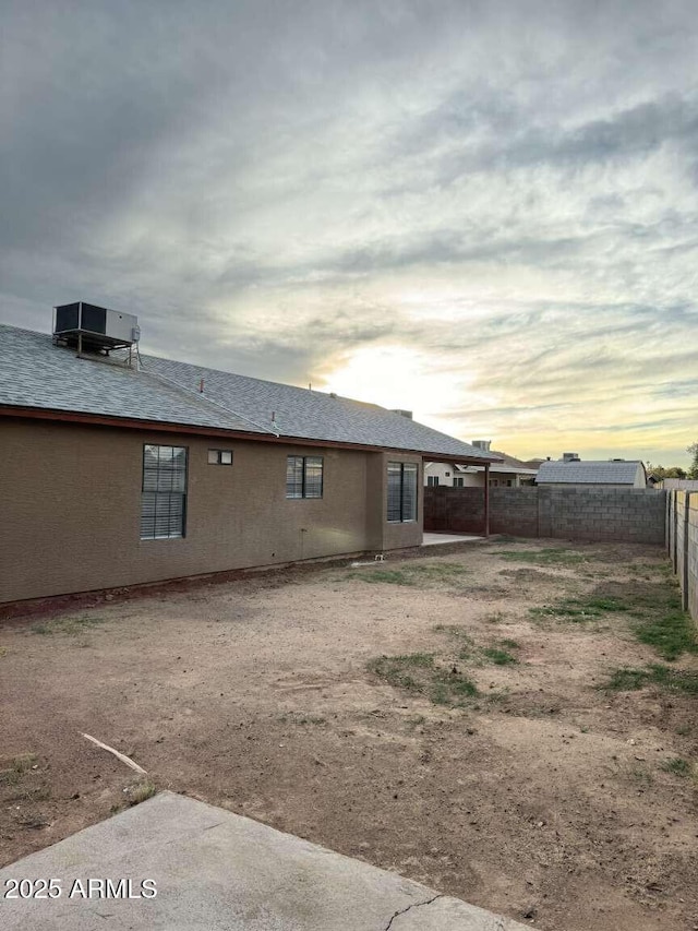 back house at dusk with central AC unit