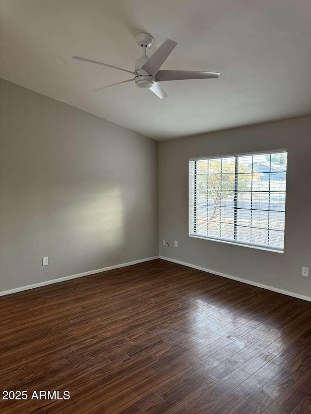 spare room featuring dark wood-type flooring and ceiling fan