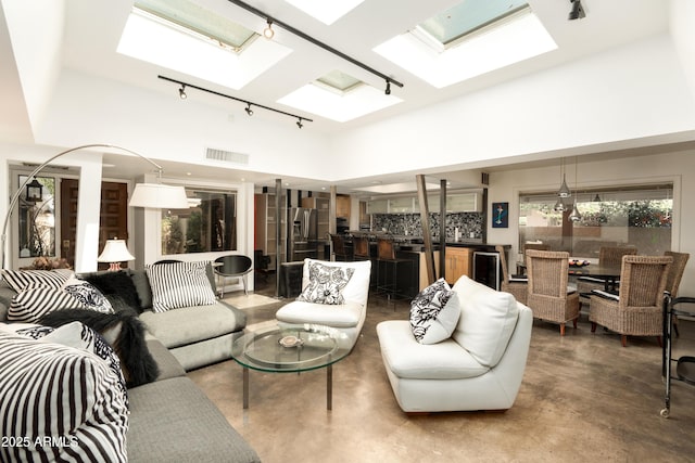 4525 N 66th St Unit 112, Scottsdale, AZ 85251 - living area with a skylight, track lighting, a towering ceiling, and finished concrete floors