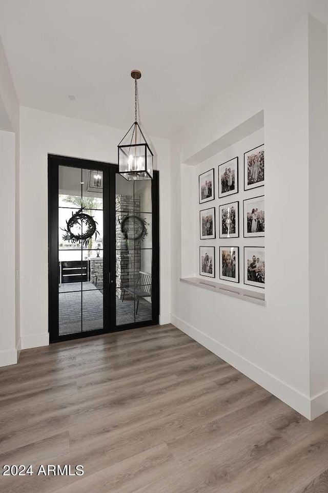 unfurnished dining area with hardwood / wood-style floors and a chandelier