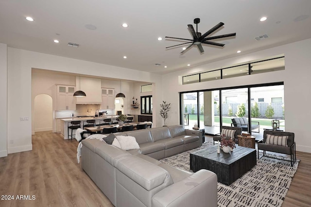 living room with ceiling fan and light hardwood / wood-style flooring