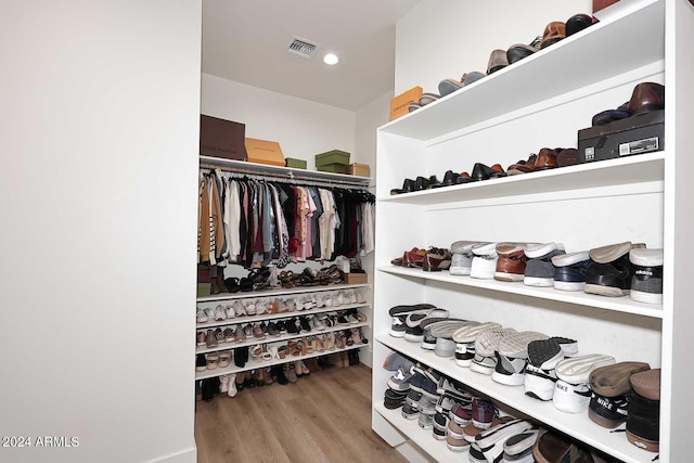 walk in closet with light hardwood / wood-style flooring