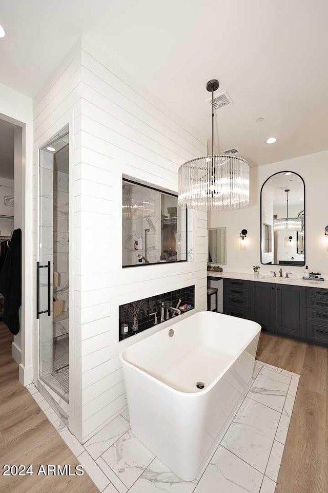 bathroom featuring vanity, separate shower and tub, a chandelier, and hardwood / wood-style flooring