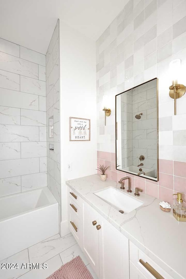 bathroom featuring backsplash, vanity, tile walls, and tiled shower / bath combo