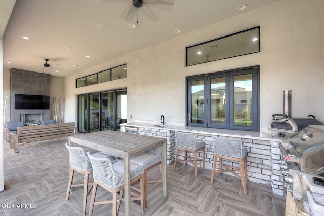 view of patio with area for grilling, ceiling fan, french doors, and an outdoor kitchen