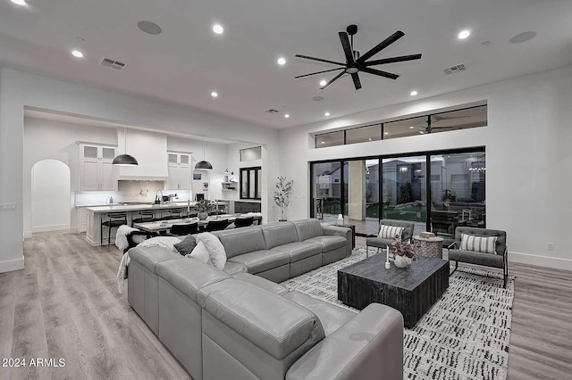 living room with light hardwood / wood-style floors, ceiling fan, and sink