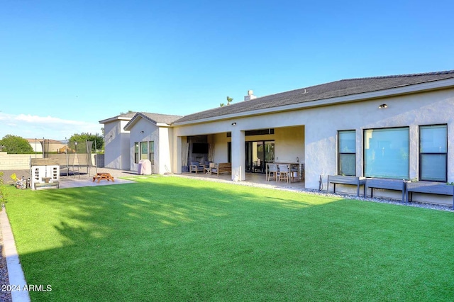 rear view of property featuring a lawn and a patio area