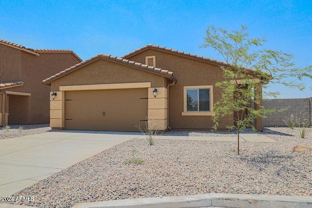 view of front of house featuring stucco siding, a garage, concrete driveway, and fence