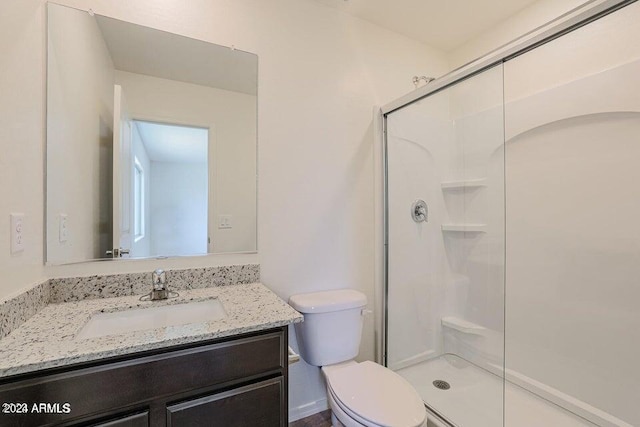 full bathroom featuring toilet, a stall shower, and vanity