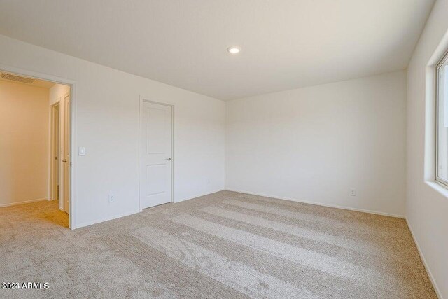 carpeted empty room with a wealth of natural light, visible vents, and recessed lighting