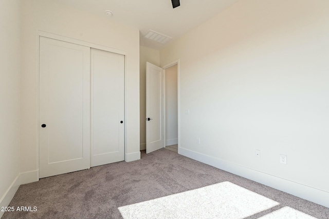 unfurnished bedroom with light carpet and a closet