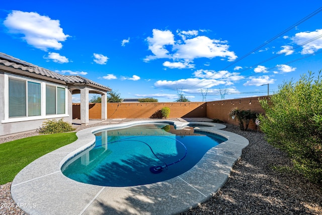 view of swimming pool with an in ground hot tub