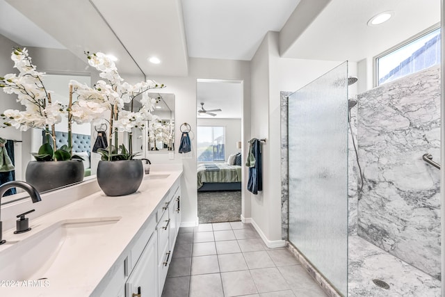 bathroom with a tile shower, tile patterned floors, vanity, and a healthy amount of sunlight