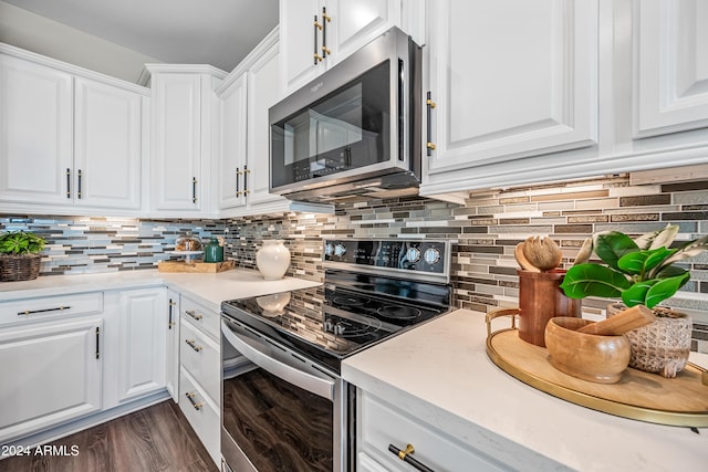 kitchen with backsplash, white cabinetry, dark wood-type flooring, and appliances with stainless steel finishes