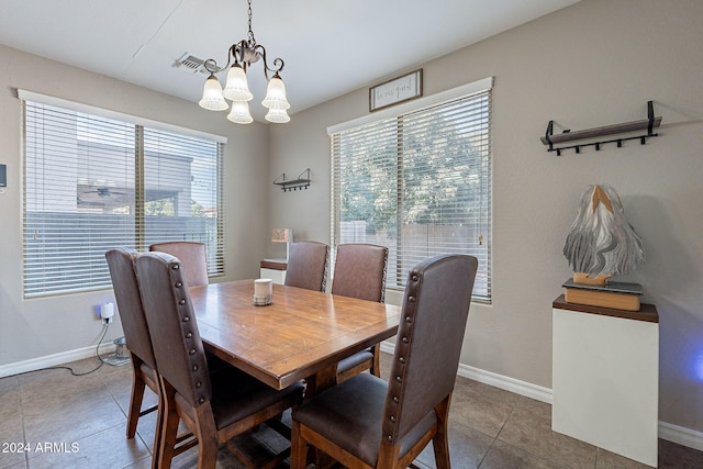 dining area with tile patterned flooring and a chandelier