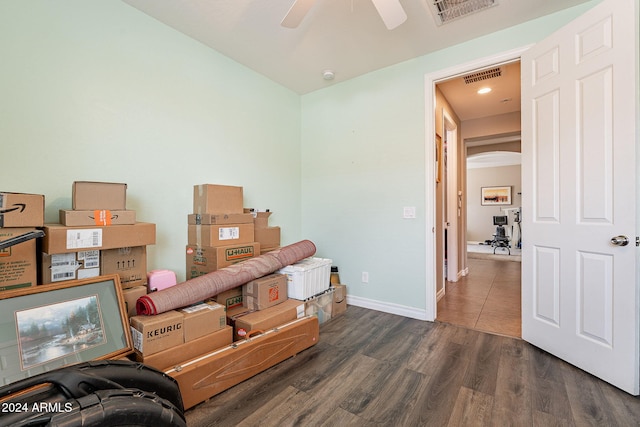 sitting room with ceiling fan and dark wood-type flooring