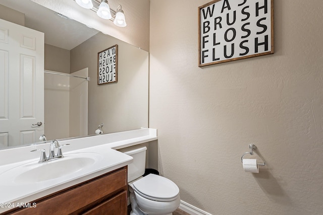 bathroom with vanity, toilet, and walk in shower