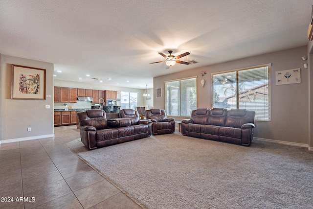 living room with light tile patterned floors, a textured ceiling, and ceiling fan