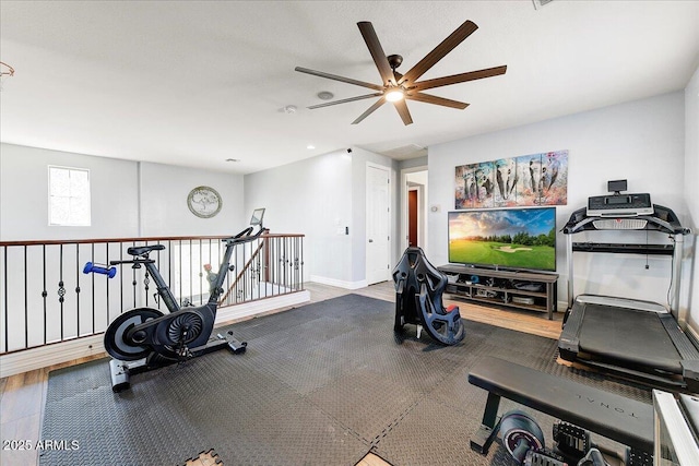 workout area with a ceiling fan and baseboards