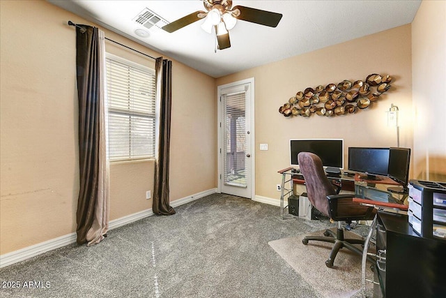 carpeted office space featuring baseboards, visible vents, and a ceiling fan