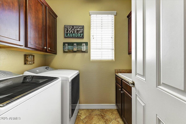 washroom with washing machine and clothes dryer, cabinet space, and baseboards