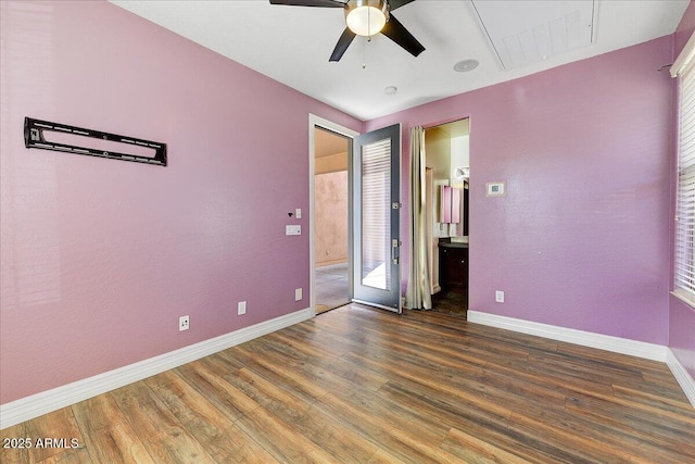 empty room with ceiling fan, wood finished floors, visible vents, and baseboards