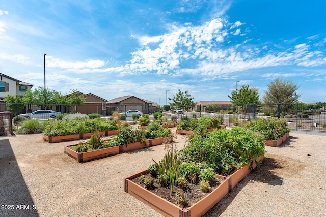 view of home's community with fence and a vegetable garden